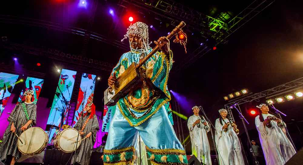 Gnawa master musician playing the traditional guenbri bass lute